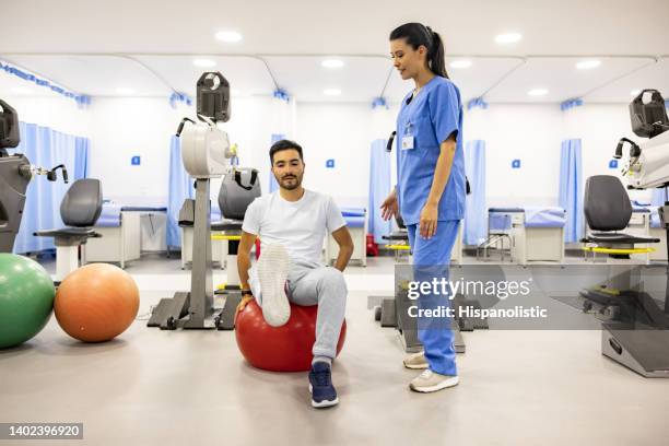 physiotherapist helping a patient while doing his exercises - knee therapy stock pictures, royalty-free photos & images