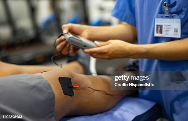 close-up on a man in physiotherapy getting electrical stimulation therapy - latina legs stockfoto's en -beelden