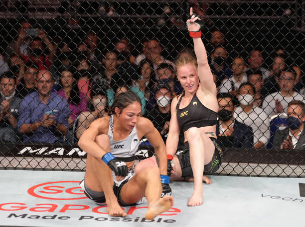 Valentina Shevchenko of Kyrgyzstan and Taila Santos of Brazil react after the conclusion of their UFC flyweight championship fight during the UFC 275...