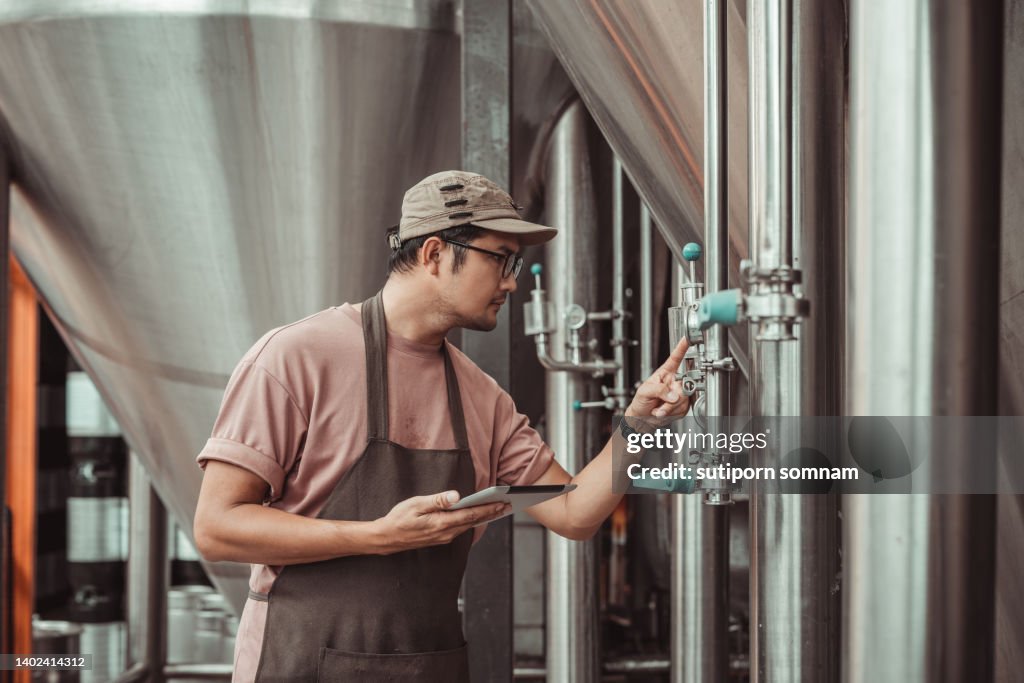 Brew brewery, brewer checks the brewing tank gauge.