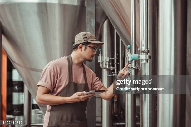 brew brewery, brewer checks the brewing tank gauge. - brewery tank stock pictures, royalty-free photos & images