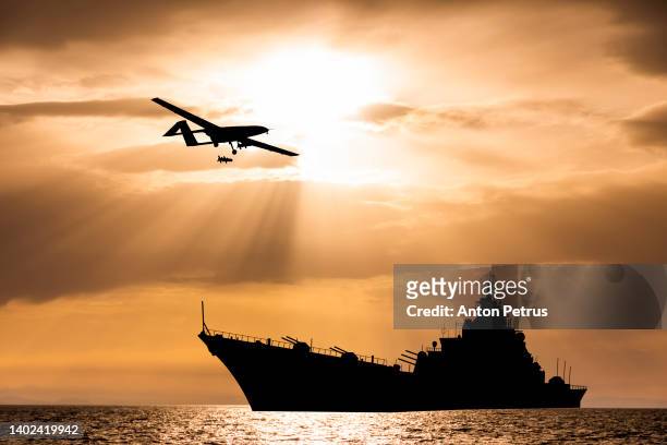 military unmanned aerial vehicle over a warship - military invasion stock pictures, royalty-free photos & images