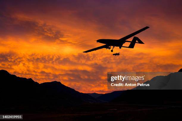 military unmanned aerial vehicle at sunset. combat drone in military conflicts - military attack stock-fotos und bilder