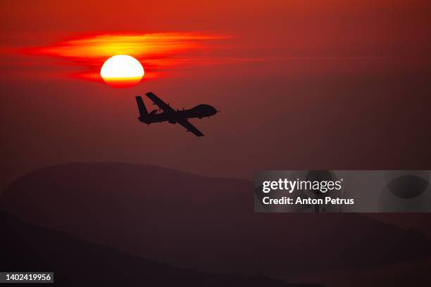 military unmanned aerial vehicle at sunset. combat drone in military conflicts - luchtaanval stockfoto's en -beelden
