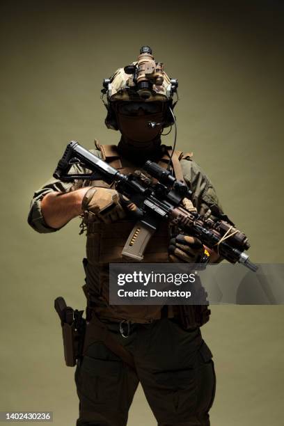soldier in armored vest, helmet, face glasses and protection kneeling and attacking with rifle - airsoft stock pictures, royalty-free photos & images