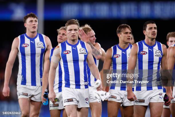 Dejected North Melbourne players walk from the ground after the round 13 AFL match between the North Melbourne Kangaroos and the Greater Western...