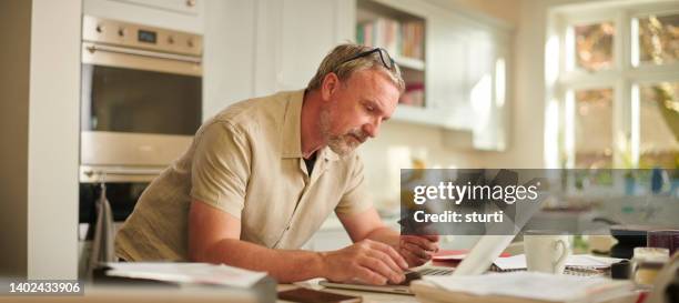 paying online with a card - man reading card stock pictures, royalty-free photos & images