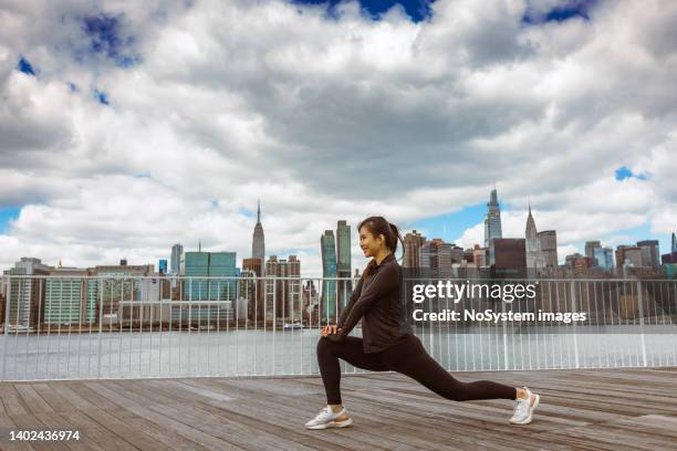 asian girl exercising outdoors new york city - long island city stockfoto's en -beelden