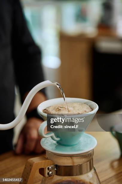 hand tropfen kaffee, barista gießt wasser auf kaffeefon mit filter - brewed coffee stock-fotos und bilder