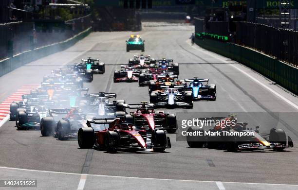 Sergio Perez of Mexico driving the Oracle Red Bull Racing RB18 leads Charles Leclerc of Monaco driving the Ferrari F1-75 and the rest of the field...