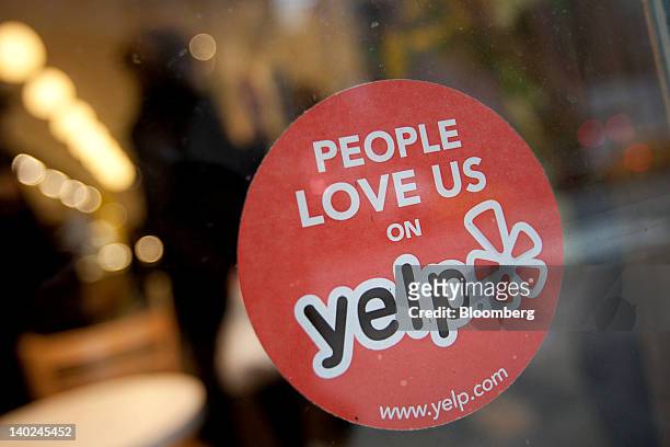 The Yelp Inc. Logo is displayed in the window of a restaurant in New York, U.S., on Thursday, March 1, 2012. Yelp Inc., the site that lets users...