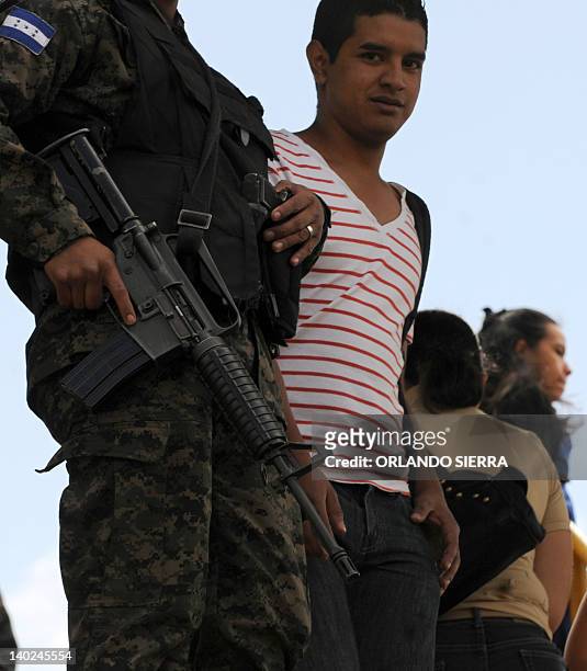 Soldiers of the Honduran Army armed with an M-16 rifle provide security at a bus stop in Tegucigalpa on March 1, 2012. To combat the increasing...
