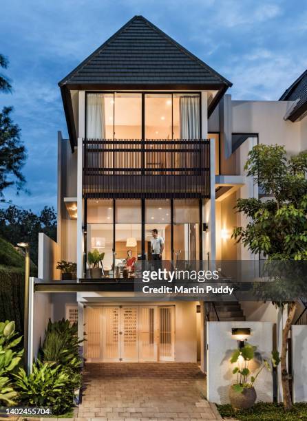 modern town house exterior with young couple inside going about their daily life - jakarta stock pictures, royalty-free photos & images