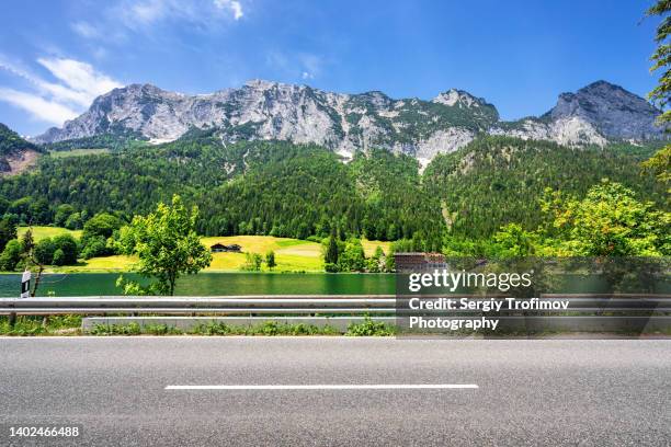 road along the lake in bavarian alps. side view - greenside stock-fotos und bilder