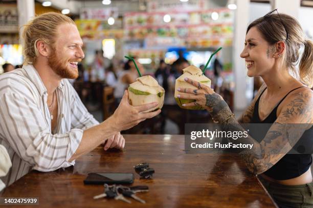 控えめなタイ料理店でココナッツを乾杯する白人カップル - 2 coconut drinks ストックフォトと画像