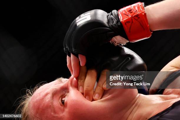 Valentina Shevchenko of Kyrgyzstan reacts as she grapples with Taila Santos of Brazil in their flyweight title bout during UFC 275 at Singapore...