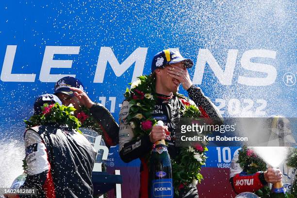 The Toyota Gazoo Racing GR010 Hybrid driver Brendon Hartley of New Zealand celebrates with team mates Sebastien Buemi and Ryo Hirakawa on the podium...