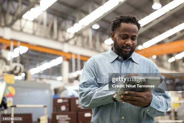 increase machine efficiency with asset performance management in manufacturing industry. a male production control manager using a digital tablet in the production line to remote asset monitoring , asset health for reduce production downtime. - data processing stockfoto's en -beelden