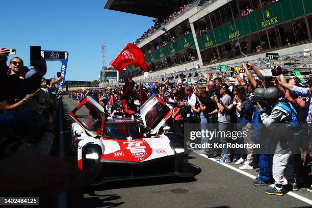 The Toyota Gazoo Racing GR010 Hybrid team of Sebastien Buemi, Brendon Hartley, Ryo Hirakawa celebrate as they drive down the pitlane after winning...