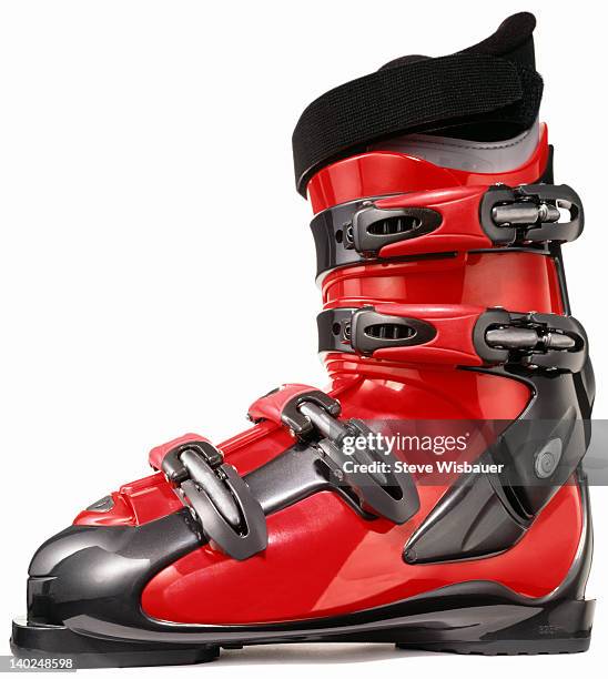 a profile of a single modern red ski boot - skischoen stockfoto's en -beelden