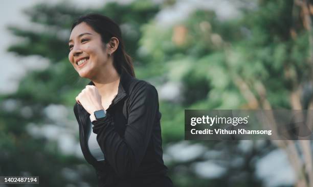 young asian women sports runs at public park - day of yoga in bangkok stock-fotos und bilder