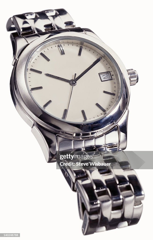 A men's silver analog wristwatch laying down