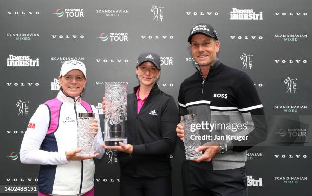Linn Grant of Sweden is presented with the trophy by tournament hosts Annika Sorenstam and Henrik Stenson after victory on Day Four of the Volvo Car...
