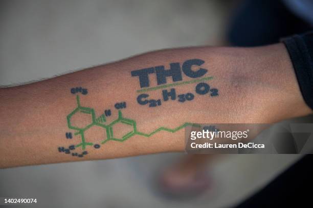 Man holds up a THC tattoo during a festival celebrating the legalization of marijuana on June 12, 2022 in Nakhon Pathom, Thailand. Highland Network,...