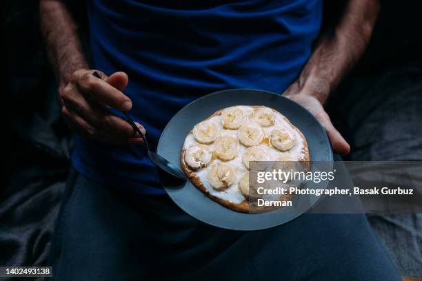 part of a man snacking at night, eating sweet food. - calcio sport imagens e fotografias de stock