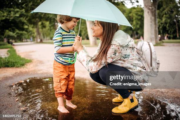 nous aimons les flaques d’eau - love umbrella photos et images de collection
