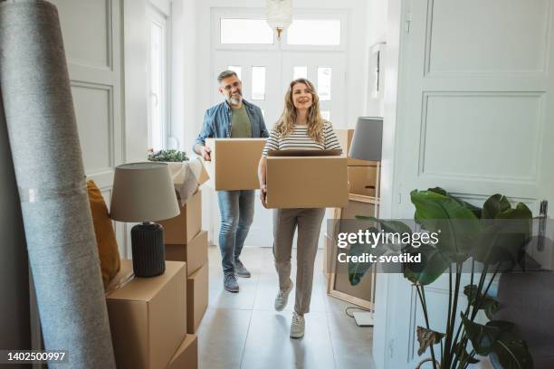 coppia matura con scatole mobili in nuova casa - house shifting foto e immagini stock