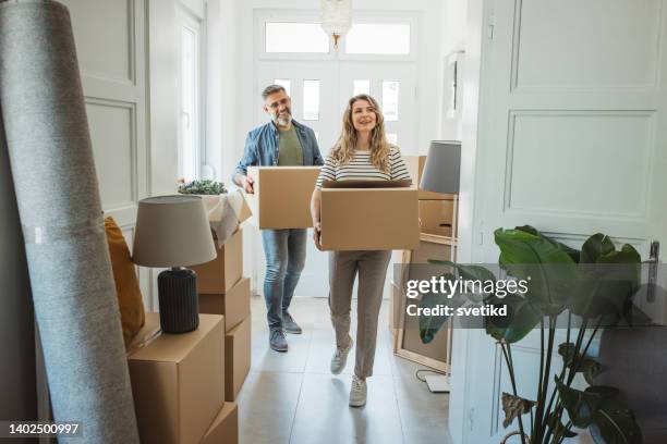 大人のカップルの新しい家でボックスを移動すると - mature couple ストックフォトと画像