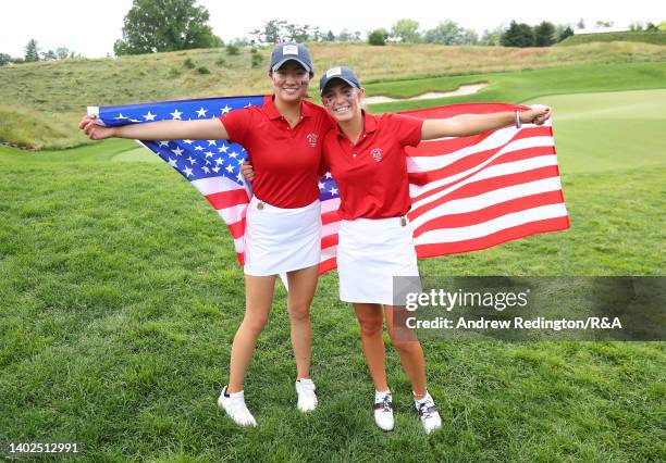 Rose Zhang and Rachel Kuehn of Team USA pose with their national flags after securing the points to win The Curtis Cup at Merion Golf Club on June...