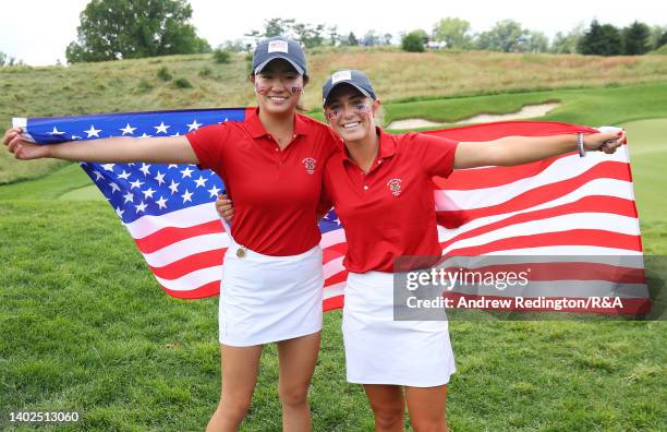 Rose Zhang and Rachel Kuehn of Team USA pose with their national flags after securing the points to win The Curtis Cup at Merion Golf Club on June...