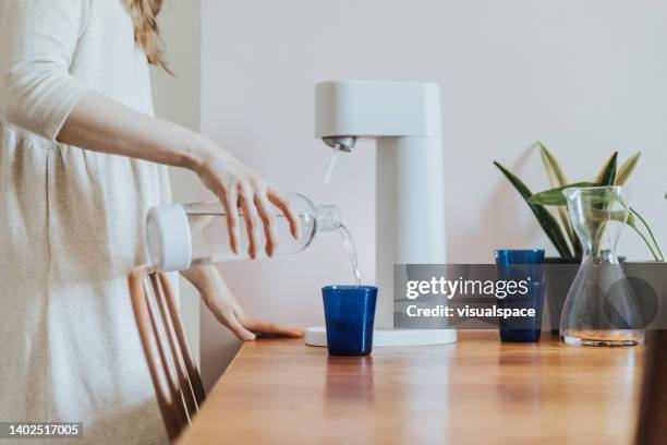 making sparkling water at home - koolzuurhoudend water stockfoto's en -beelden