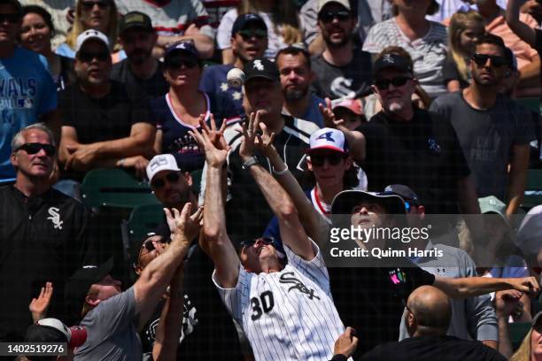 Fans go after a foul ball in the fourth inning of the game between the Chicago White Sox and the Texas Rangers at Guaranteed Rate Field on June 12,...