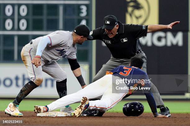 Jeremy Pena of the Houston Astros steals second base as Miguel Rojas of the Miami Marlins applies the tag as umpire Manny Gonzalez makes the call at...