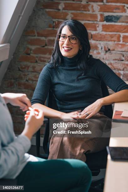 caucasian woman listening to an anonymous colleague - employee engagement abstract stock pictures, royalty-free photos & images