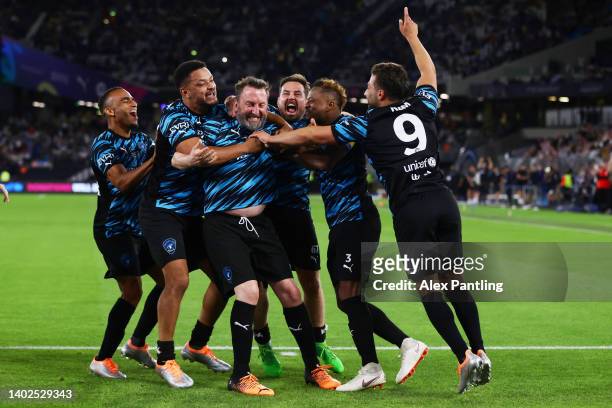 Lee Mack of Team World XI celebrates with team mates after scoring the winning penalty in a the penalty shoot out during the Soccer Aid for Unicef...