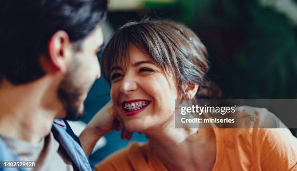 affectionate couple relaxing at home - adult retainer stockfoto's en -beelden