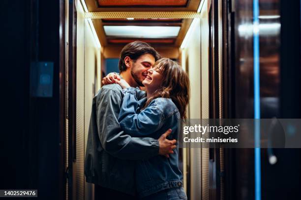 cheerful couple kissing in the elevator - versierd jak stockfoto's en -beelden