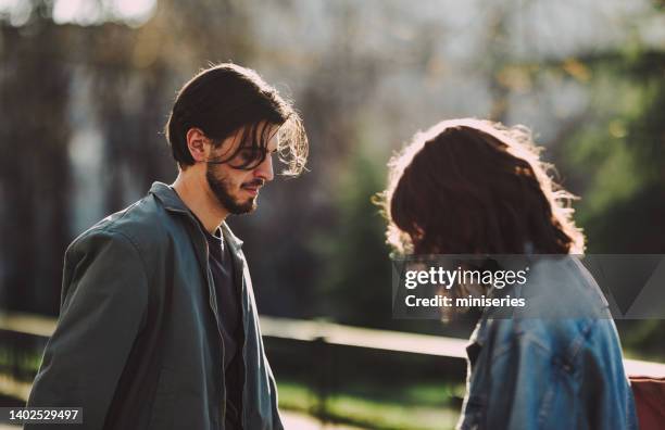 sad couple standing together outdoors - seasonal sadness stock pictures, royalty-free photos & images