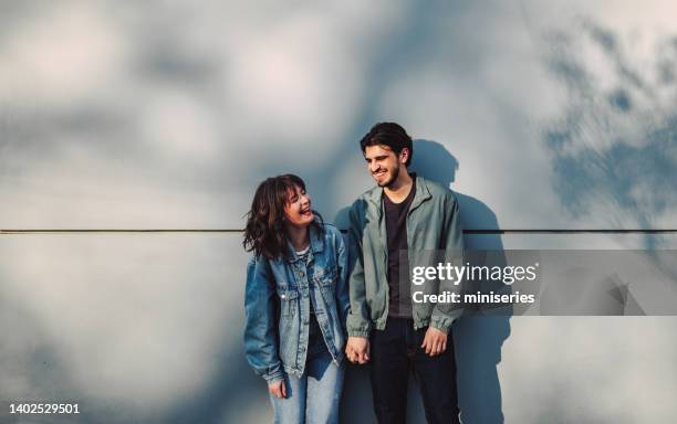 portrait of happy couple standing outdoors - versierd jak stockfoto's en -beelden