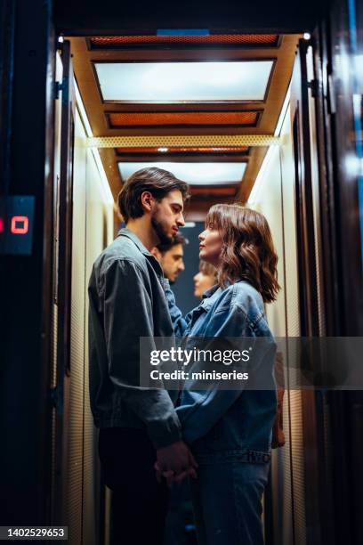 couple standing together in the elevator - woman holding hand mirror stock pictures, royalty-free photos & images