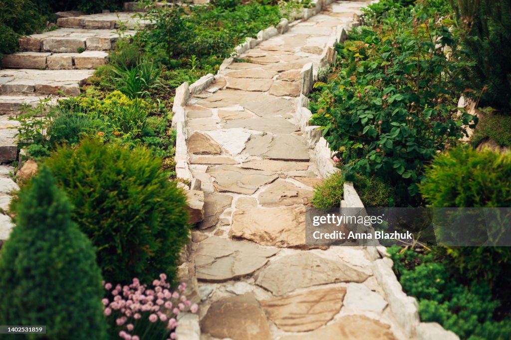 Stone walkway in garden made of big yellow stones, garden landscaping design.