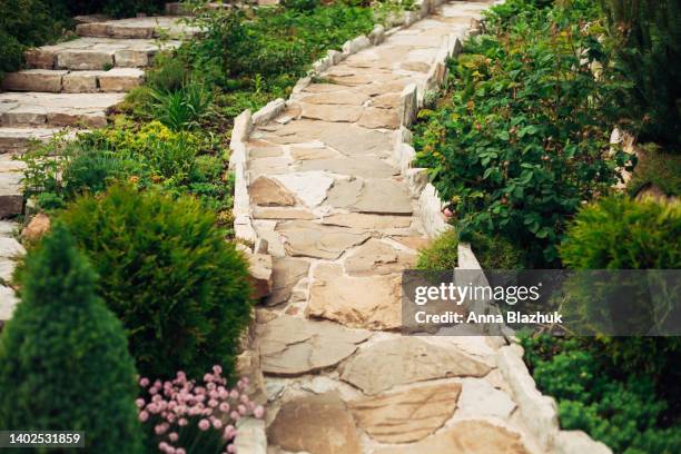 stone walkway in garden made of big yellow stones, garden landscaping design. - 鋪路石板 個照片及圖片檔