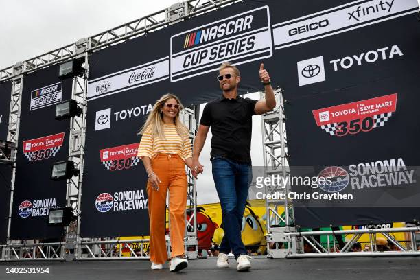 Actress Candace Cameron Bure and husband, and former NHL player Valeri Bure walk onstage during driver intros prior to during pre-race ceremonies...