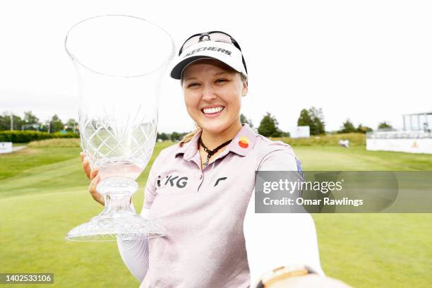 Brooke Henderson of Canada pretends to take a selfie while holding the trophy on the 18th green after winning the ShopRite Classic at Seaview Bay...