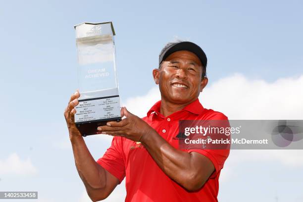 Thongchai Jaidee of Thailand holds the winner's trophy on the 18th green after winning the American Family Insurance Championship at University Ridge...