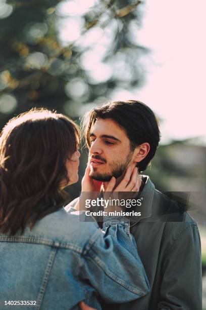 loving couple sharing a romantic moment outdoors - versierd jak stockfoto's en -beelden